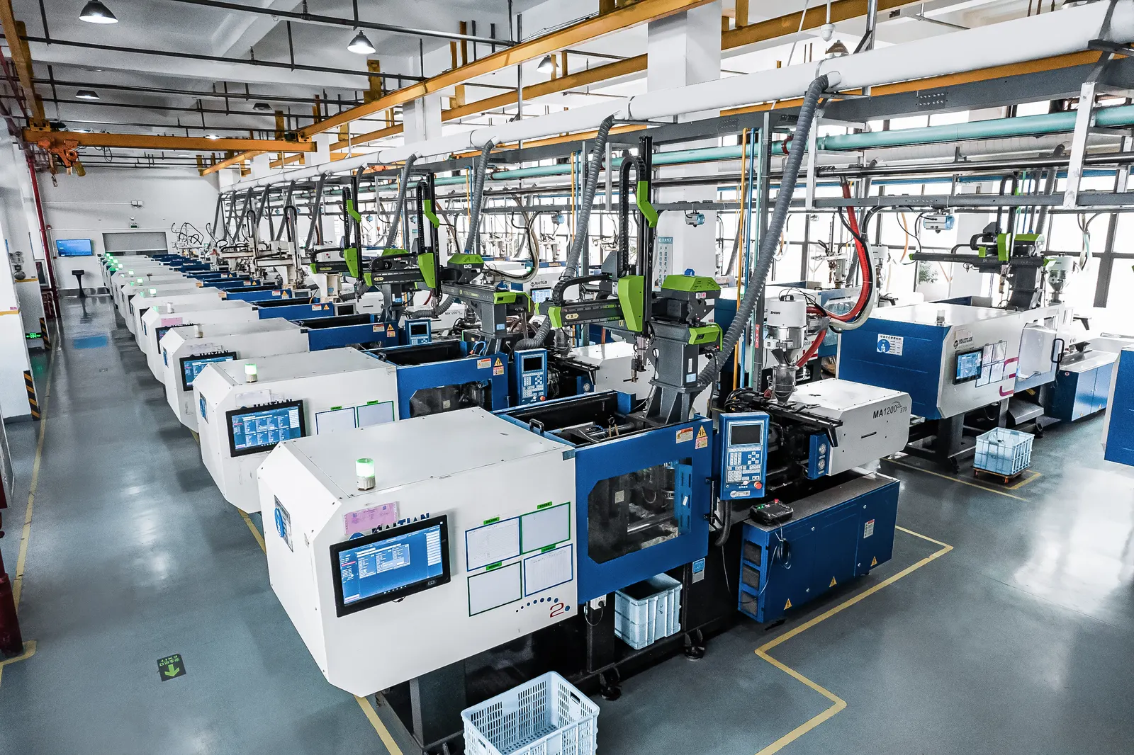 Injection molding machines with robotic part handling — production facility scene shared by our supply partner